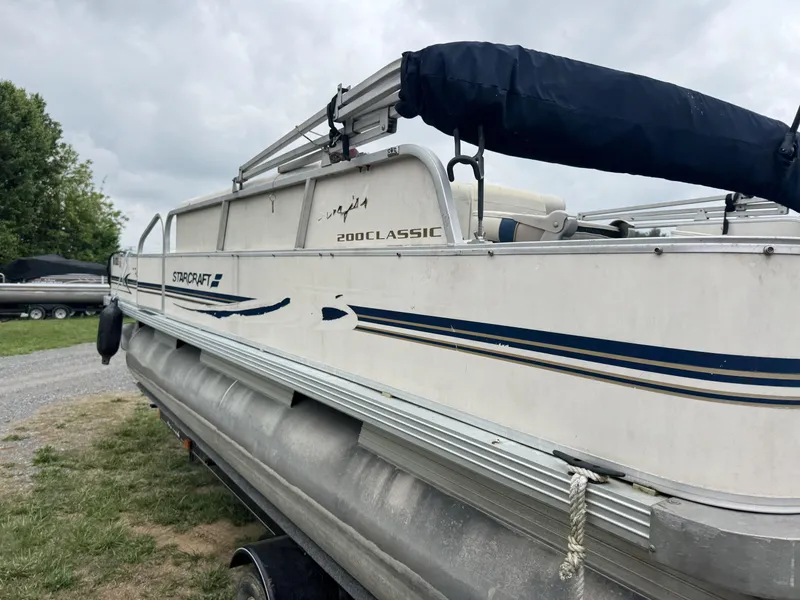 Slide: The Image of Starcraft 2000 Classic pontoon boat on trailer, overcast sky background. - 11