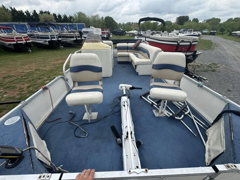 Slide: The Image of 2000 Starcraft 200 Classic boat with blue carpet and white seating, docked among other boats. - 5