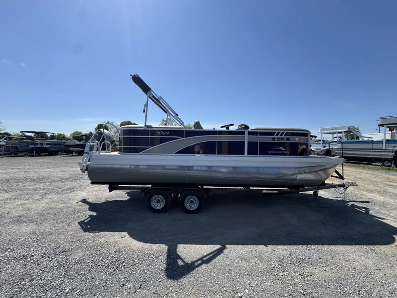 Slide: The Image of 2022 Bennington 22 SXSR pontoon boat on trailer under clear blue sky. - 19