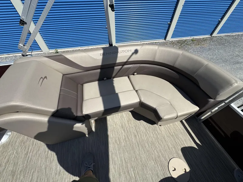 Slide: The Image of 2022 Bennington 22 SXSR boat interior with beige seating and blue storage background. - 26