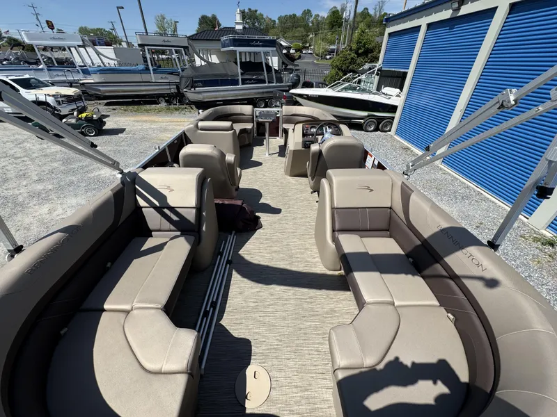 Slide: The Image of 2022 Bennington 22 SXSR pontoon boat with spacious seating, parked near storage units. - 28