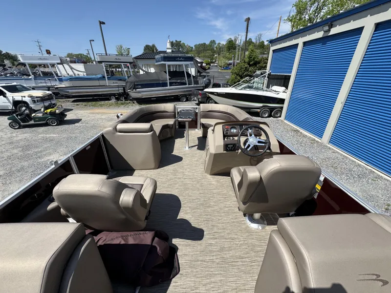Slide: The Image of 2022 Bennington 22 SXSR pontoon boat with spacious seating and modern dashboard, parked outdoors. - 29