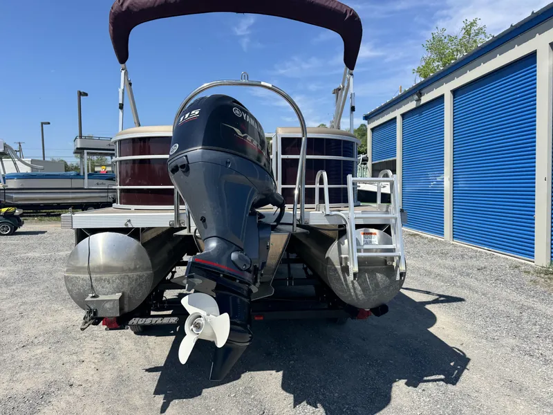 Slide: The Image of 2022 Bennington 22 SXSR pontoon boat with Yamaha outboard motor, parked near storage units. - 3