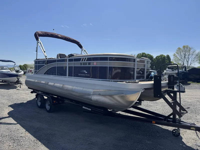 Slide: The Image of 2022 Bennington 22 SXSR pontoon boat on trailer under clear blue sky. - 4