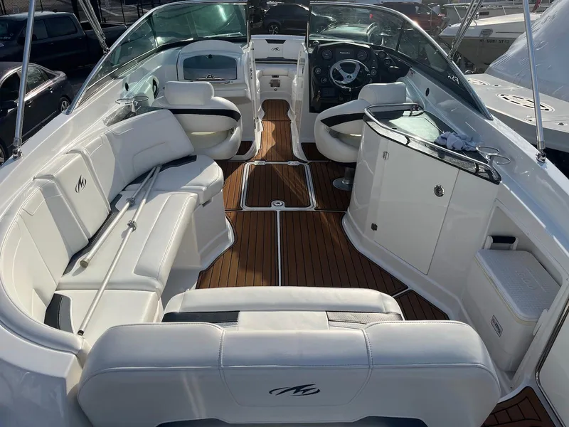 Slide: The Image of 2015 Monterey 264FSX boat interior with white seating and wood flooring. - 1