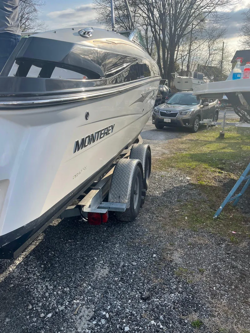 Slide: The Image of 2015 Monterey 264FSX boat on trailer, parked outdoors on gravel. - 12