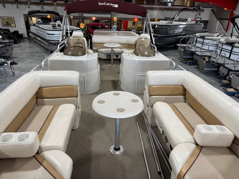 Slide: The Image of 2008 G3 LX 26C pontoon boat with beige seating and table, displayed indoors. - 6