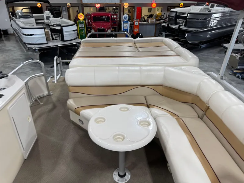 Slide: The Image of 2008 G3 LX 26C pontoon boat interior with beige seating and cupholder table. - 8