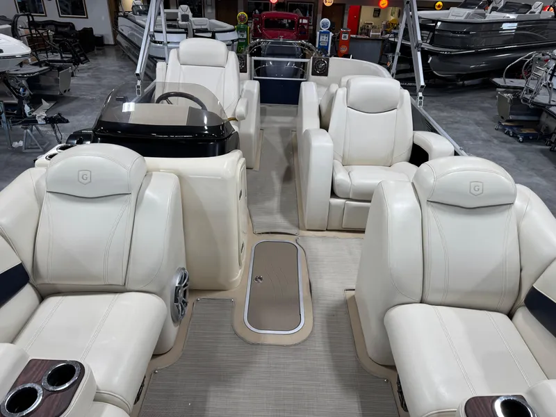 Slide: The Image of 2016 AquaPatio 220 AD boat interior with luxurious white seating and modern dashboard. - 10