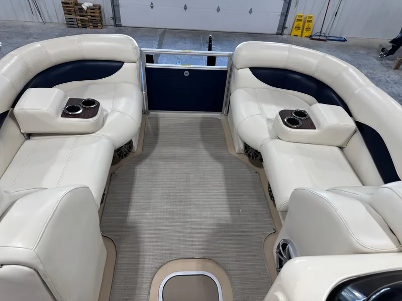 Slide: The Image of 2016 AquaPatio 220 AD boat interior with beige seating and cup holders. - 11