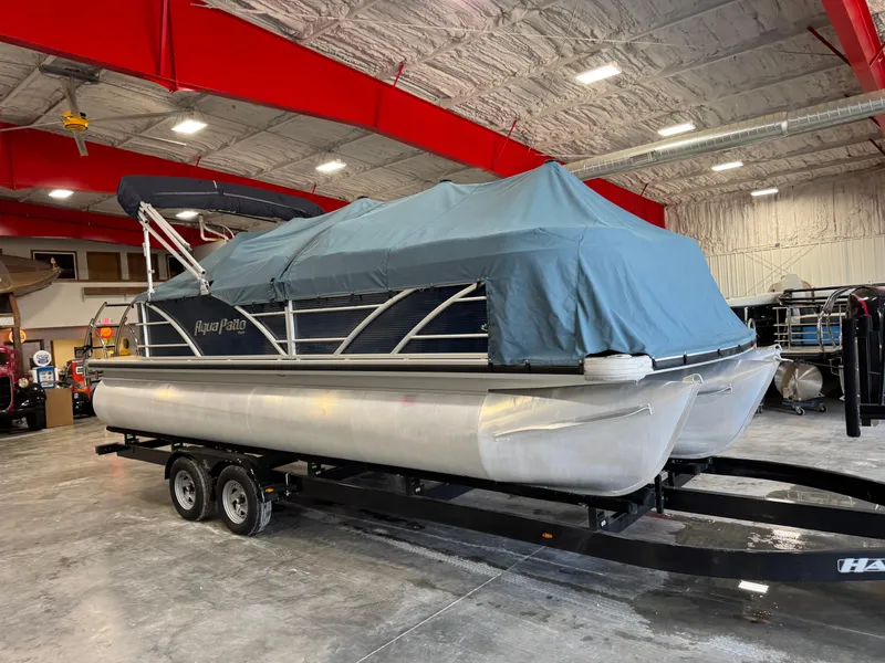 Slide: The Image of 2016 AquaPatio 220 AD pontoon boat covered in a garage on a trailer. - 12
