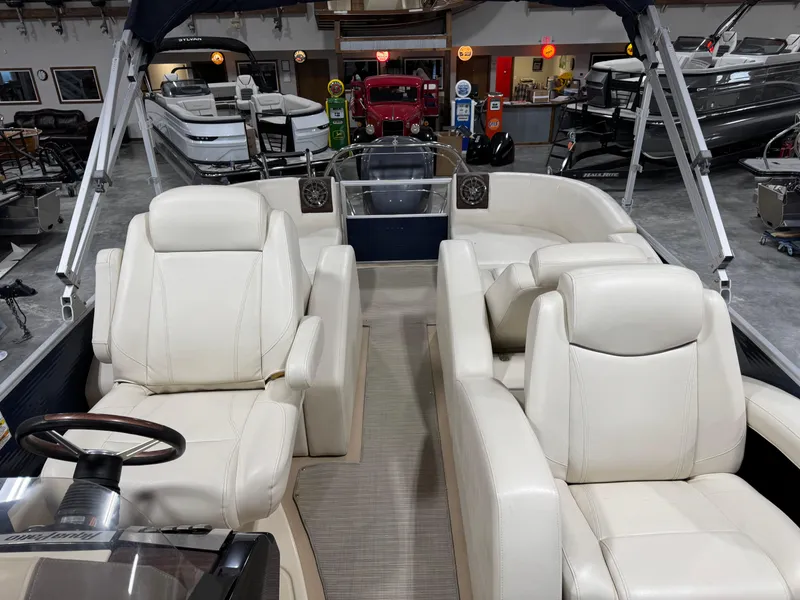 Slide: The Image of 2016 AquaPatio 220 AD pontoon boat interior with plush white seating in showroom. - 9