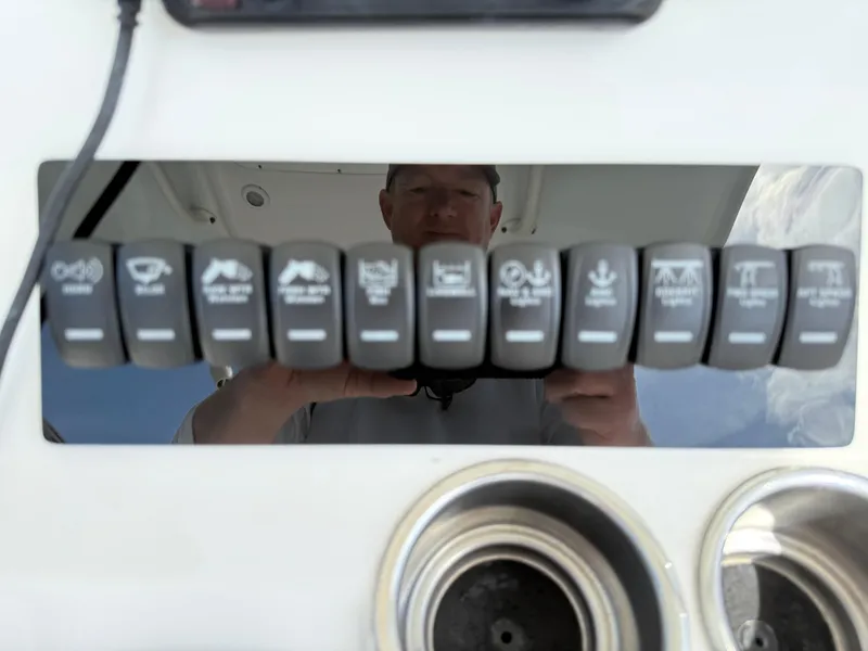 Slide: The Image of Control panel of a 2016 Regulator 23 boat with labeled switches and cup holders. - 17