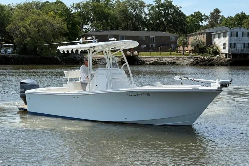 Slide: The Image of 2016 Regulator 23 boat on calm water near residential area. - 2