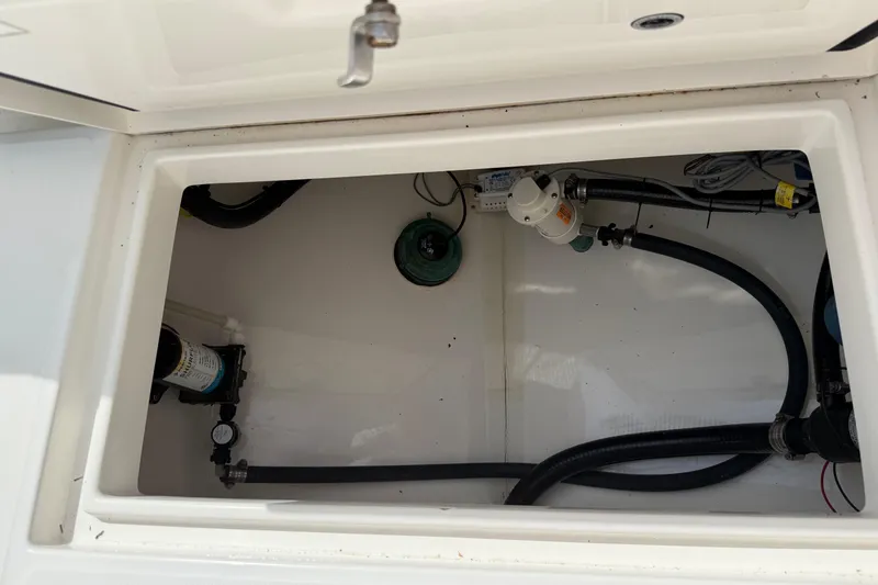 Slide: The Image of Open storage compartment in 2016 Regulator 23 boat, showing hoses and equipment. - 29