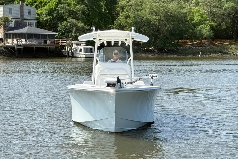 Slide: The Image of 2016 Regulator 23 boat on calm water near a wooded shoreline. - 3