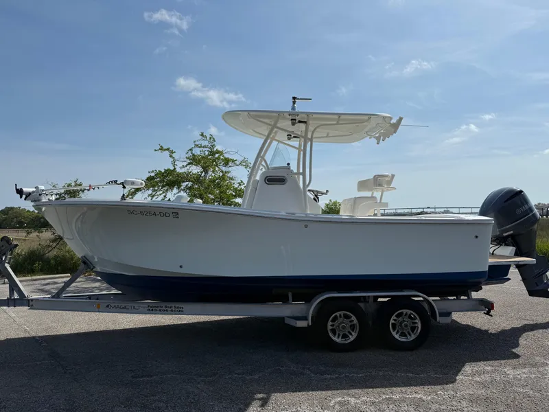 Slide: The Image of 2016 Regulator 23 boat on trailer, side view, under clear blue sky. - 8