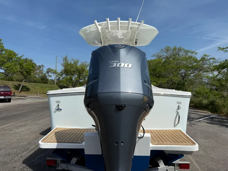 Slide: The Image of 2016 Regulator 23 boat with Yamaha 300 outboard motor, parked outdoors. - 9