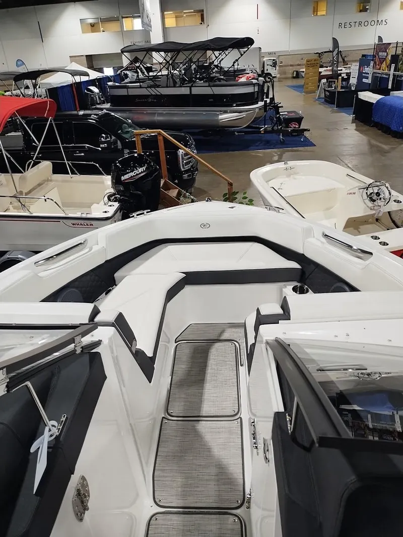 Slide: The Image of 2025 Cobalt R6 Surf boat interior at a boat show, showcasing sleek design and seating. - 11