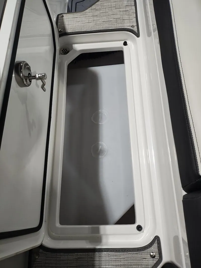 Slide: The Image of 2025 Cobalt R6 Surf boat storage compartment with open hatch and secure lock. - 19