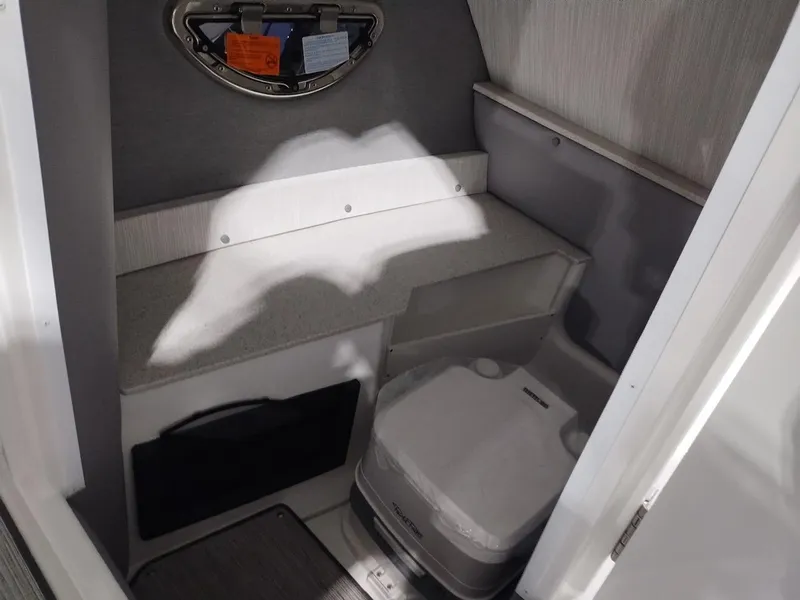 Slide: The Image of 2025 Cobalt R6 Surf boat interior with compact toilet and storage area. - 22