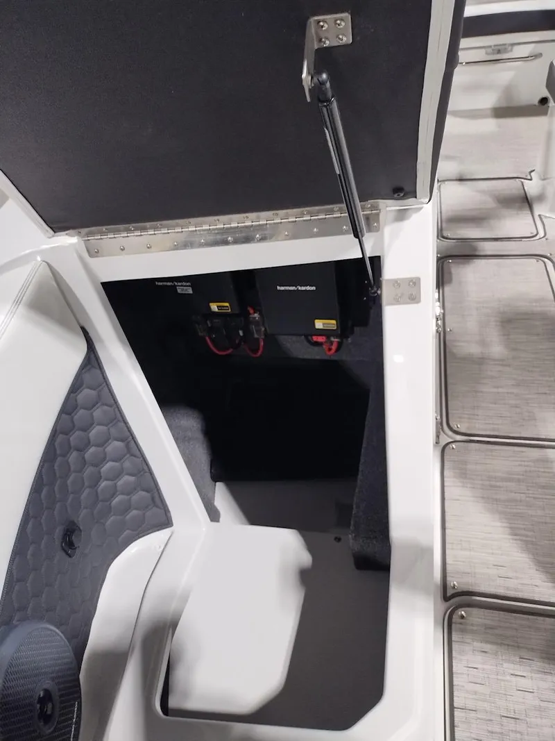 Slide: The Image of 2025 Cobalt R6 Surf boat storage compartment with open hatch and visible battery setup. - 8