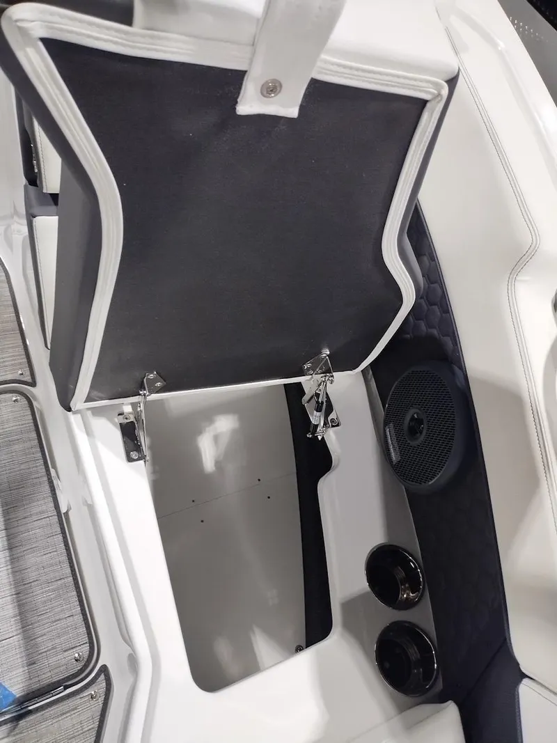 Slide: The Image of 2025 Cobalt R6 Surf boat storage compartment with open lid and speaker. - 9