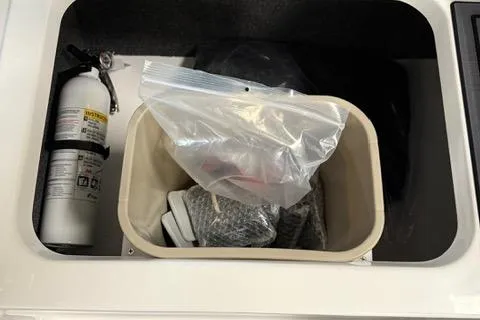 Slide: The Image of Storage compartment in 2025 Cobalt CS22 boat with fire extinguisher and supplies. - 18