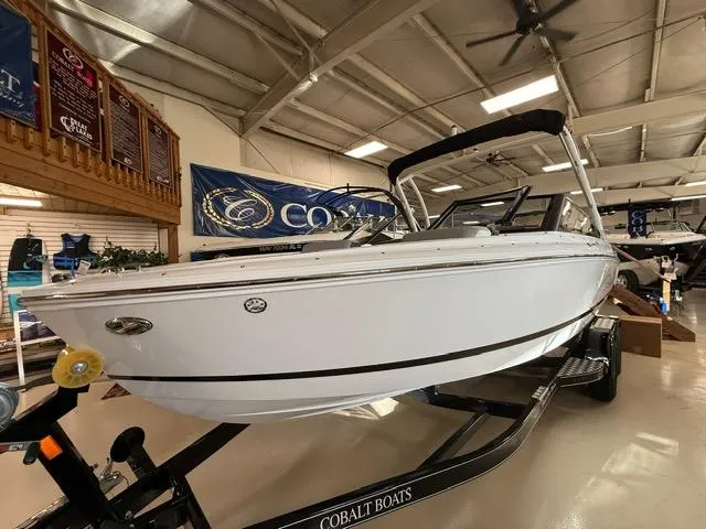 Slide: The Image of 2025 Cobalt CS22 boat displayed indoors on a trailer. - 2