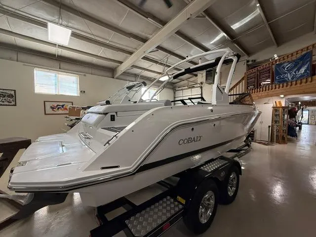 Slide: The Image of 2025 Cobalt CS22 boat in showroom, white exterior, on trailer. - 4