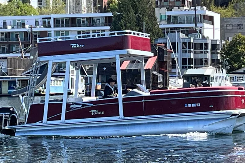 Slide: The Image of 2023 Tahoe Pontoon Cascade Cruise Funship on water, urban backdrop, sunny day. - 13