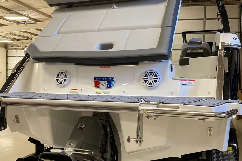 Slide: The Image of 2025 Cobalt R6 boat rear view with swim platform and speakers in a garage setting. - 3