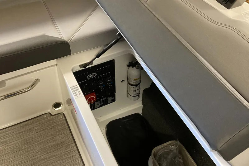 Slide: The Image of 2025 Cobalt R6 boat storage compartment with control panel and fire extinguisher. - 7