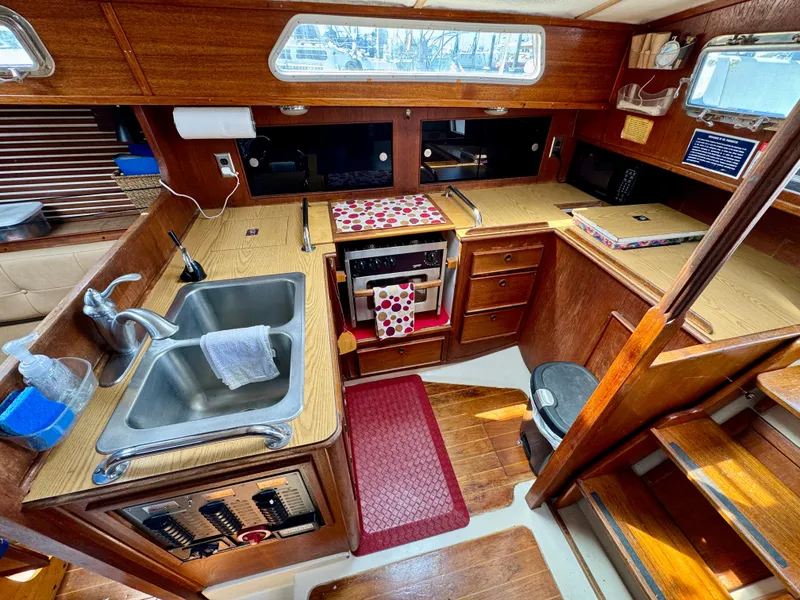 Slide: The Image of 1979 Irwin Citation 39 yacht kitchen with wooden cabinetry and stainless steel sink. - 10
