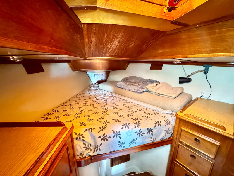 Slide: The Image of Cozy cabin interior of 1979 Irwin Citation 39 sailboat with wooden furnishings and floral bedding. - 15