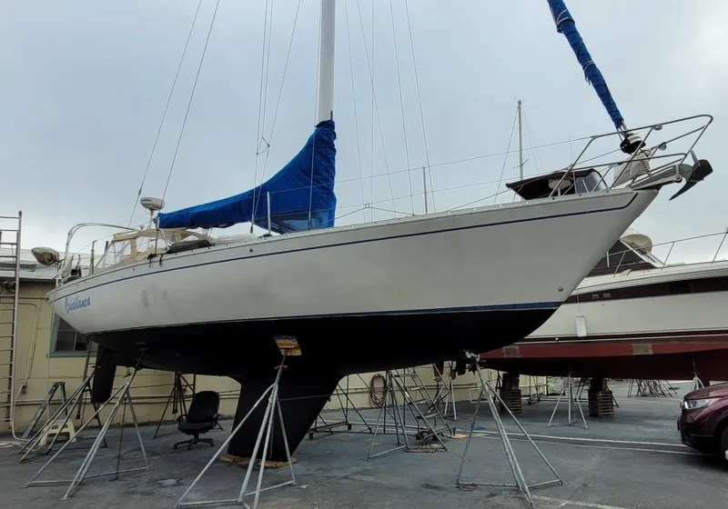 Slide: The Image of 1979 Irwin Citation 39 sailboat on stands, with blue sail cover, in a boatyard. - 3