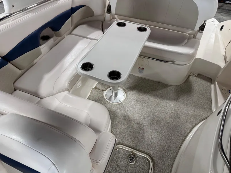 Slide: The Image of 2009 Chaparral 276 SSX boat interior with seating and table, featuring cup holders. - 11
