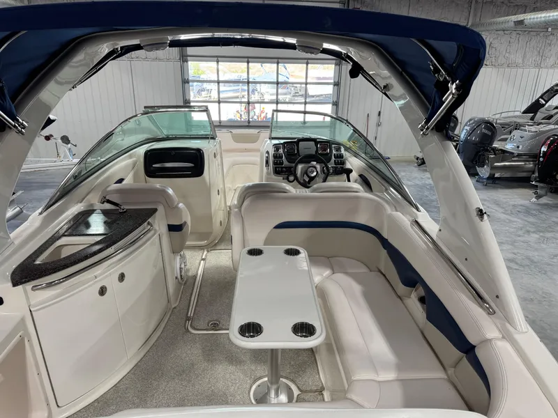 Slide: The Image of 2009 Chaparral 276 SSX boat interior with seating, table, and helm in a showroom. - 7