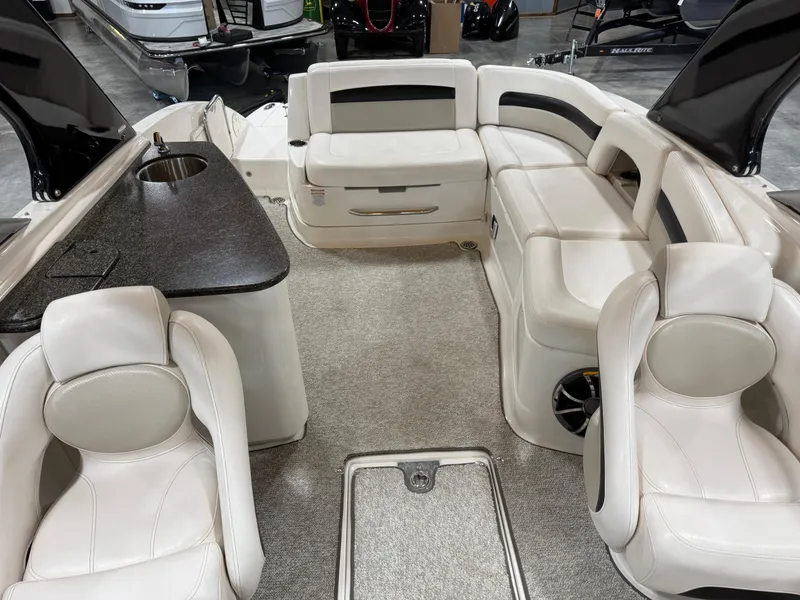Slide: The Image of 2008 Chaparral Sunesta 284 boat interior with white seating and a small sink area. - 7