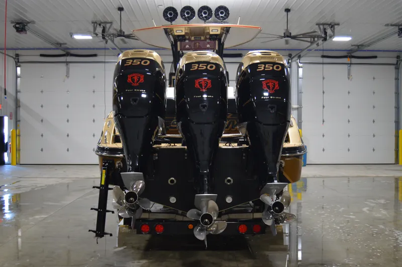 Slide: The Image of 2017 Statement 380 Open boat with triple 350 horsepower engines in a garage. - 12
