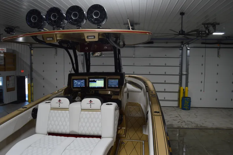 Slide: The Image of 2017 Statement 380 Open boat in garage, featuring advanced navigation systems and luxurious seating. - 28