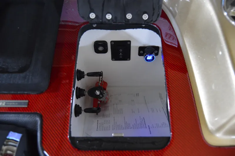Slide: The Image of Control panel inside a 2017 Statement 380 Open boat, featuring switches and a red carbon fiber finish. - 44