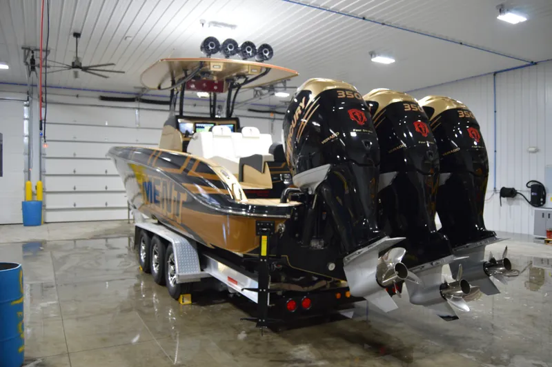 Slide: The Image of 2017 Statement 380 Open boat with triple 350 engines in a garage setting. - 5