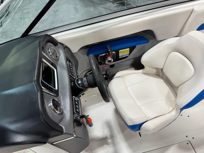 Slide: The Image of 2018 Chaparral 246 SSi Surf boat cockpit with steering wheel and white seat. - 8