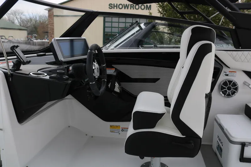 Slide: The Image of 2025 Yamaha Boats 222SE interior with modern dashboard and captain's chair in showroom. - 11