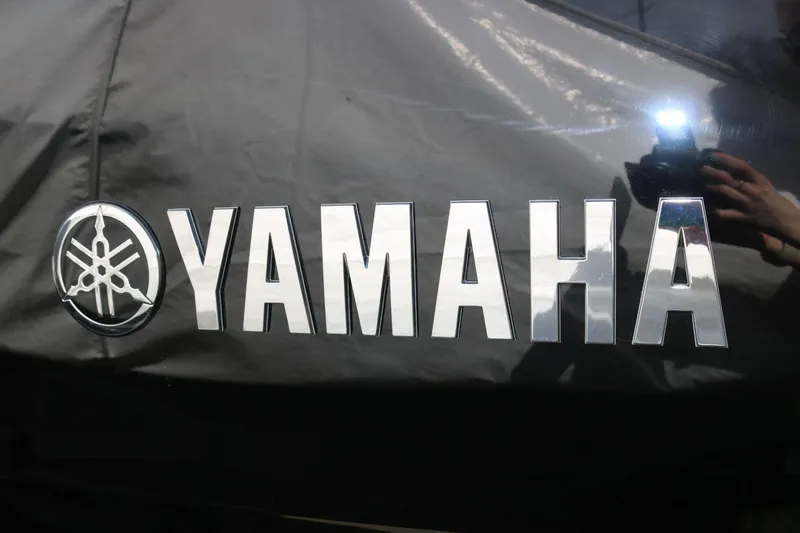 Slide: The Image of Yamaha logo on 2025 Yamaha Boats 222SE, reflective surface with camera flash. - 25