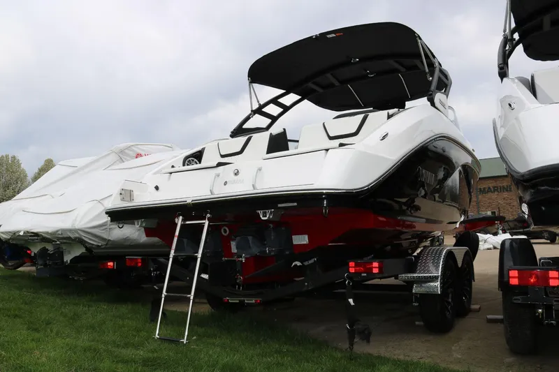 Slide: The Image of 2025 Yamaha Boats 222SE on trailer, rear view, parked outdoors. - 3