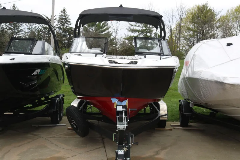 Slide: The Image of 2025 Yamaha Boats 222SE on trailer, parked outdoors between other boats. - 4