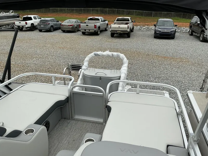 Slide: The Image of 2025 Avalon LSZ 23 Rear Lounger pontoon boat with spacious seating, parked in a gravel lot. - 11
