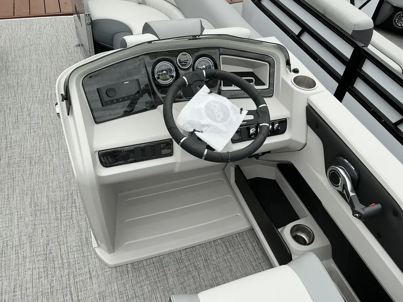 Slide: The Image of 2025 Avalon LSZ 23 Rear Lounger boat dashboard with steering wheel and controls. - 13